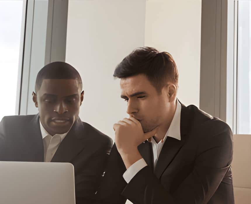 a person in a suit and tie sitting in front of a laptop